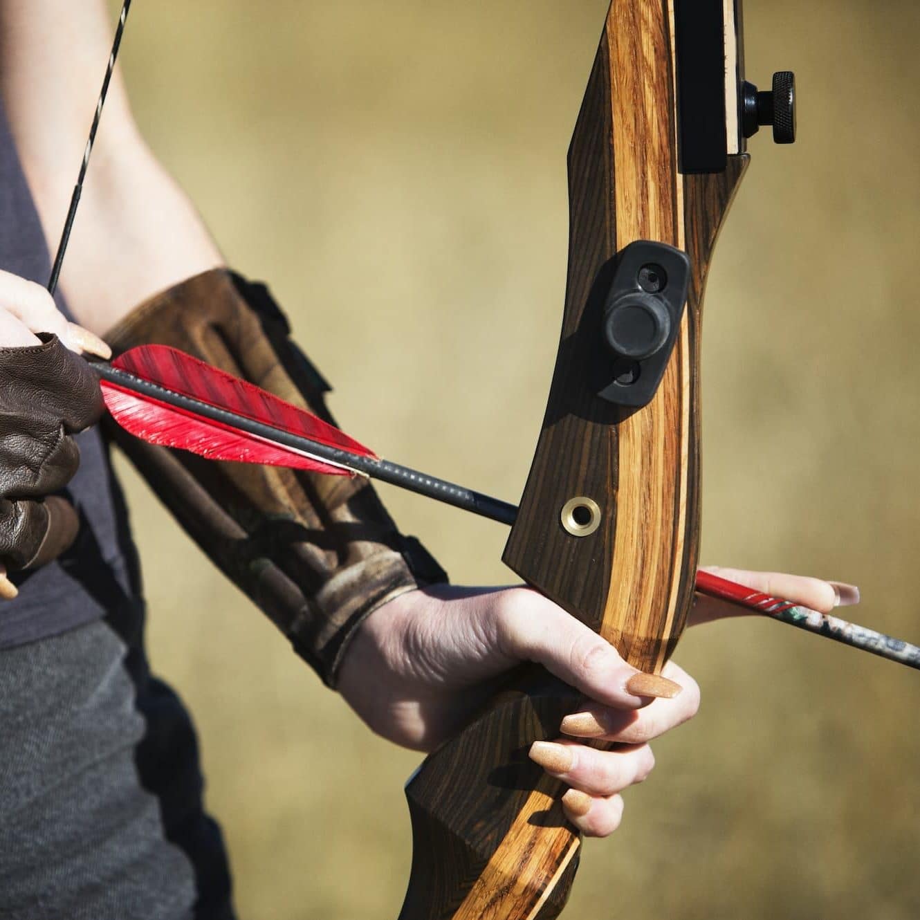 Close-up Of Woman Holding Bow And Arrow